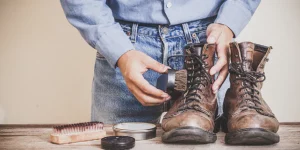 شخصی در حال واکس زدن کفش کار